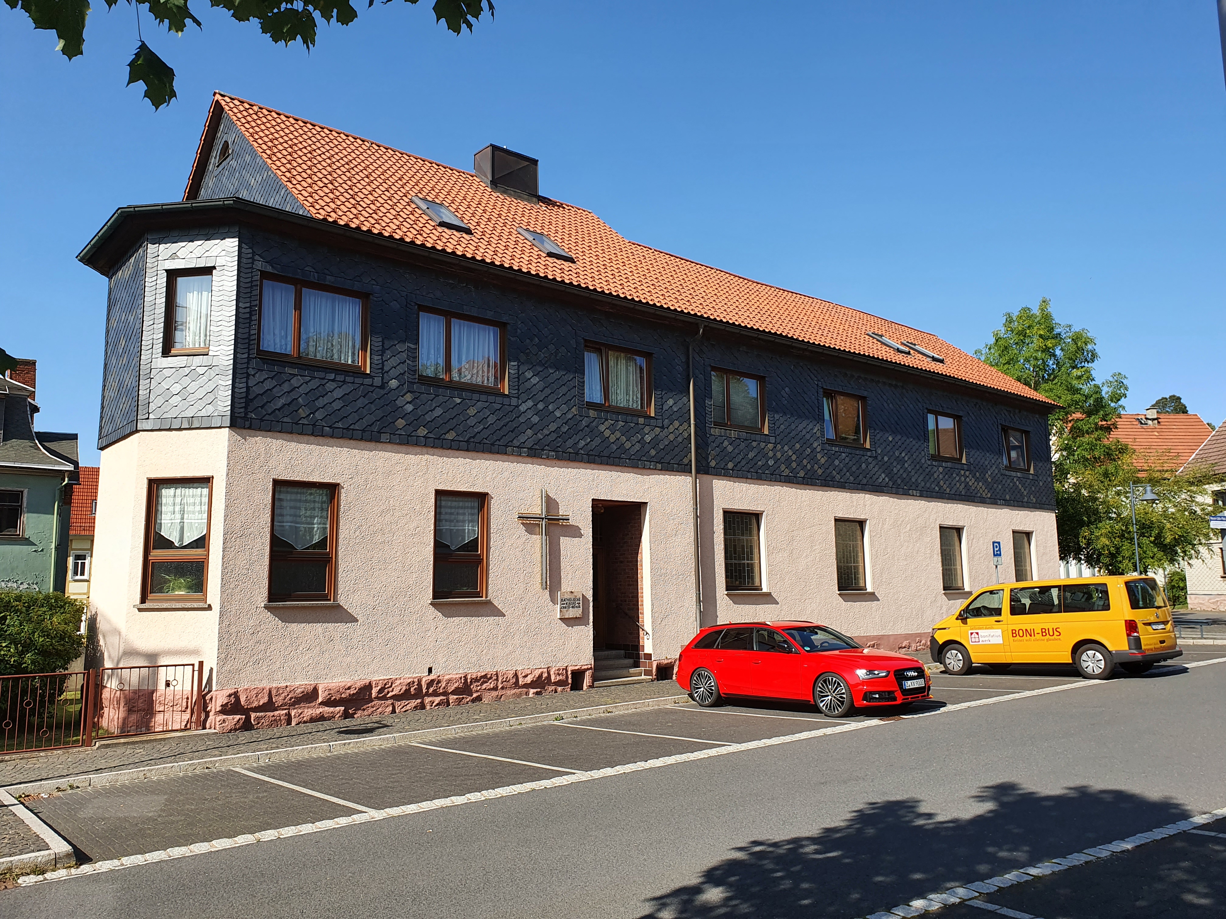 Katholisches Gemeindehaus in Zella-Mehlis mit Schieferfassade und Kreuz an der Wand